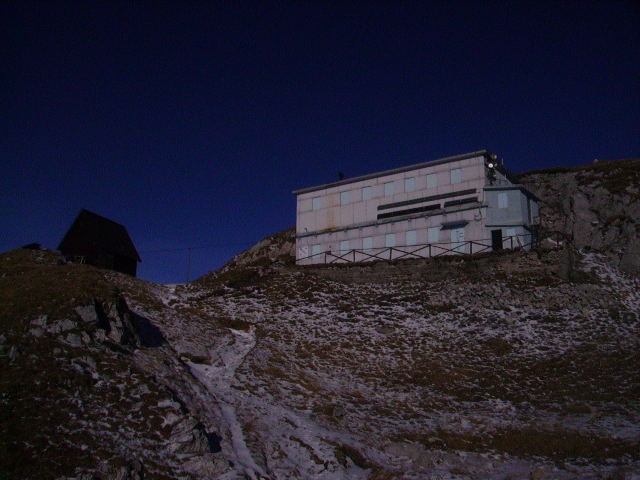 Koča stoji tik pod vrhom Črne prsti 1844 m.n.v. Italjani, ki so zgradili najprej bunker, k