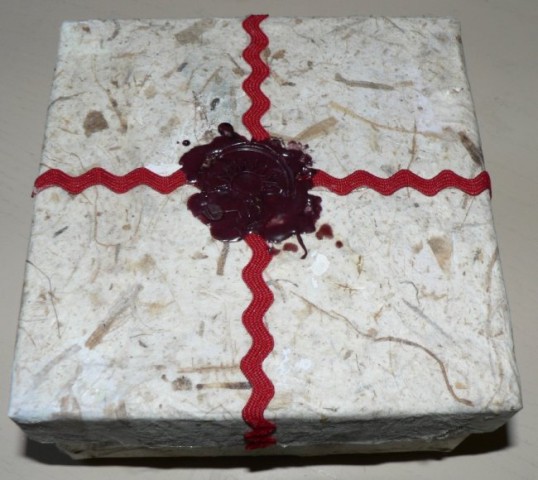 škatla, kaširana z natur papirjem, dodan trakec in štempelj 