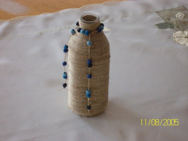 Steklenička  ovita z vrvico in  lesenimi kroglicami